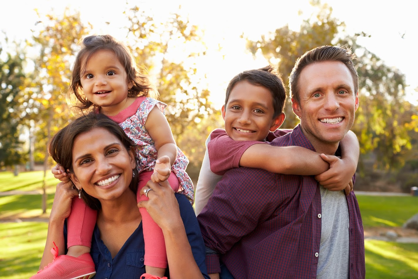 Mixed_Race_Parents_Carry_Their_Kids_Piggyback_in_Park